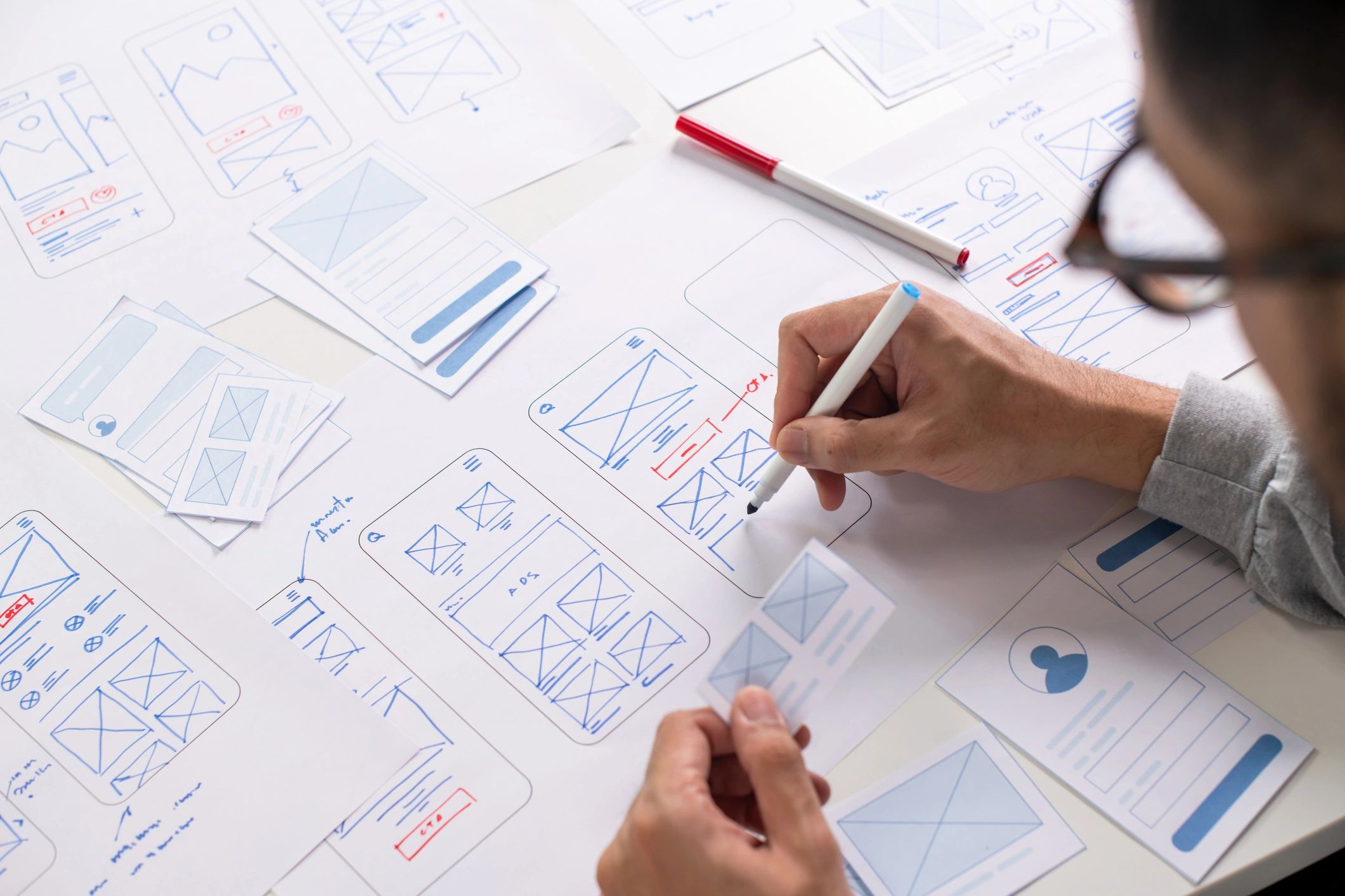 Designer working on a UX wireframe at a desk